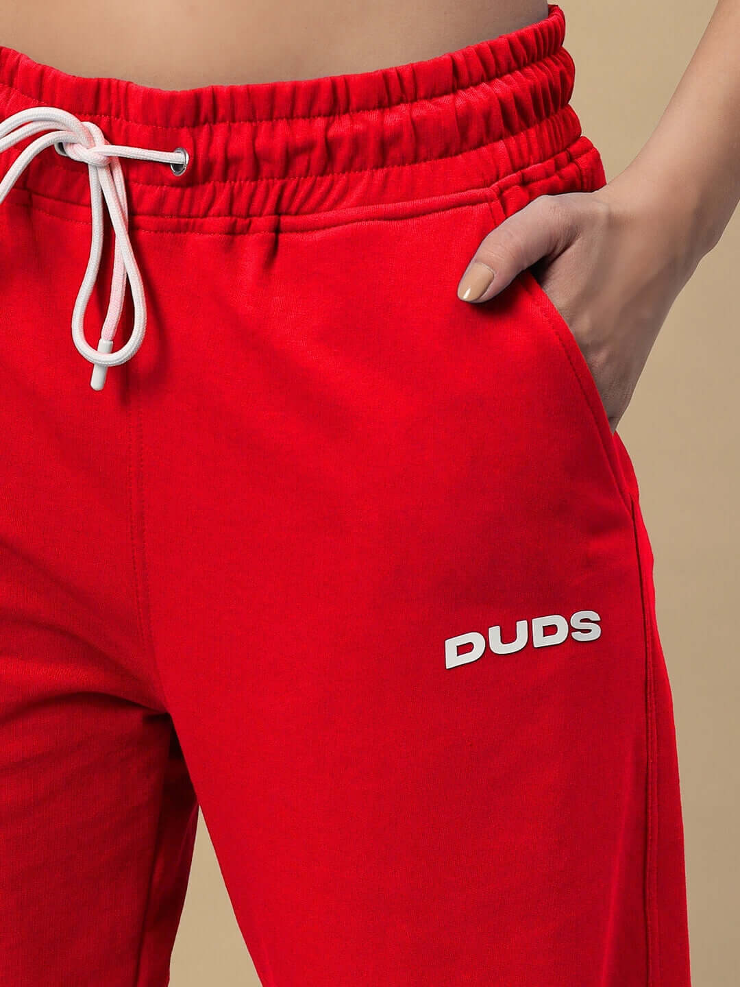 Model wearing red women's Hershey side slit joggers by DUDS, featuring an elastic waistband and drawstring closure.