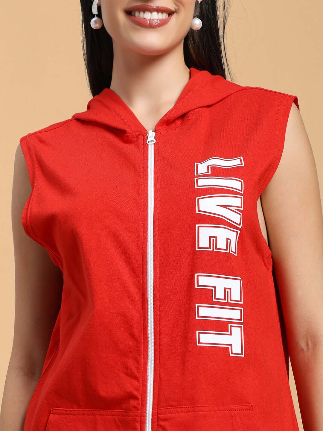 Close-up of a woman wearing a red Live Fit gym hooded T-shirt, showcasing the sleeveless design and bold front zipper.