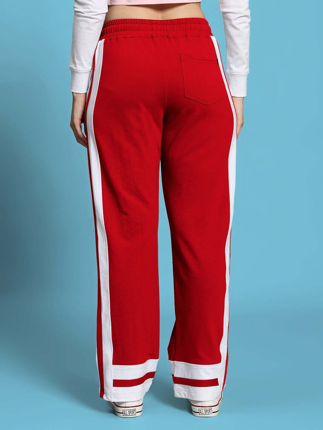 Back view of women's red jogger with white side stripes, featuring elastic waistband and pocket detailing, designed by DUDS.