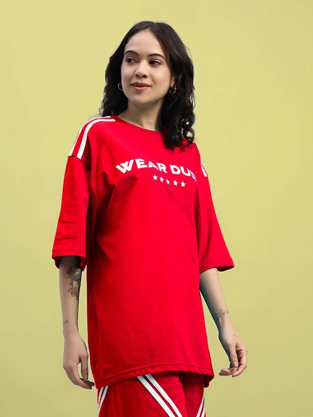 Woman wearing oversized red star jumper t-shirt with stripe design, made from premium cotton fabric.