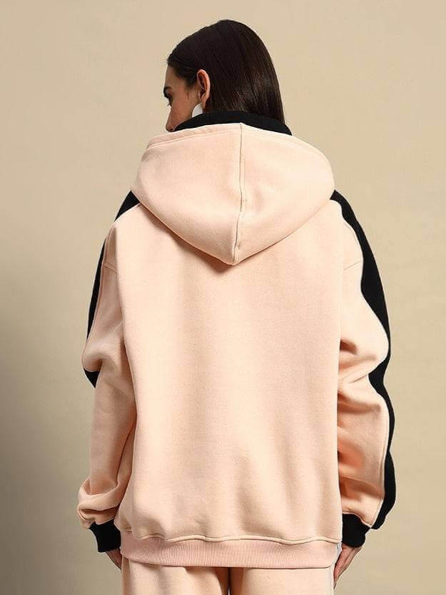 Back view of women's regiment fleece hoodie in beige-black, featuring a cozy hood and contrasting sleeves.