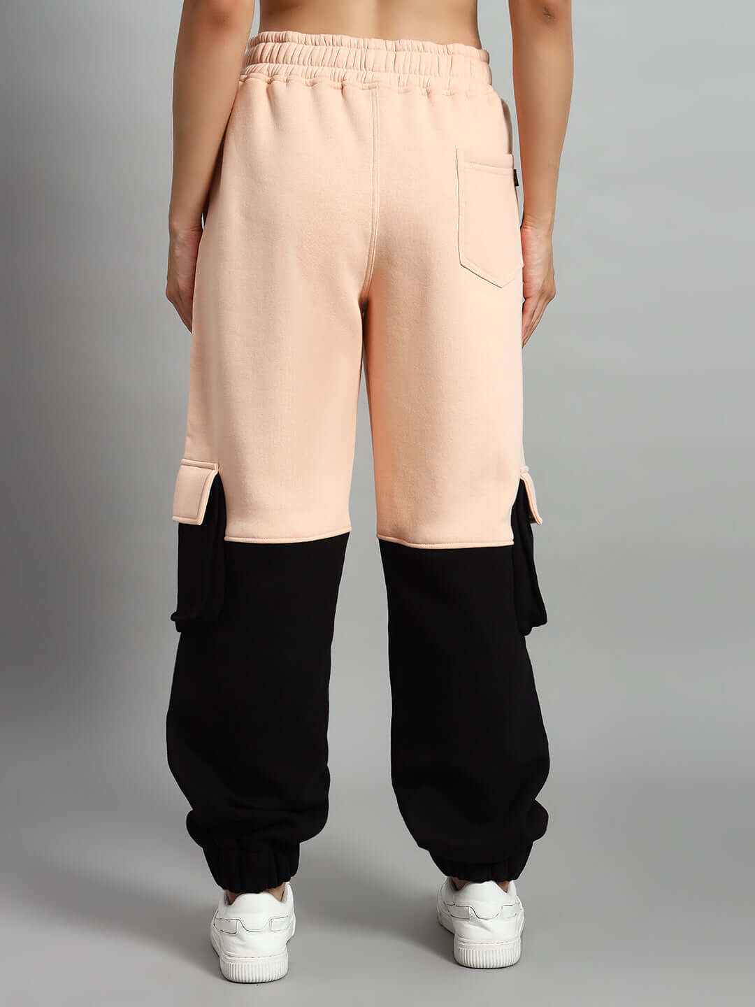 Back view of WOMEN REGIMENT FLEECE PANT BEIGE BLACK showcasing elastic waistband and ribbed hems.