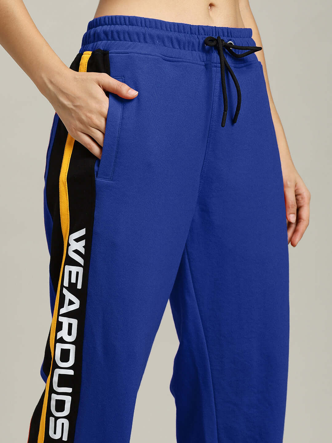 Close-up of Women's Roger Relaxed-Fit Joggers in Blue with side stripes and drawstring waistband showcasing comfortable fabric.