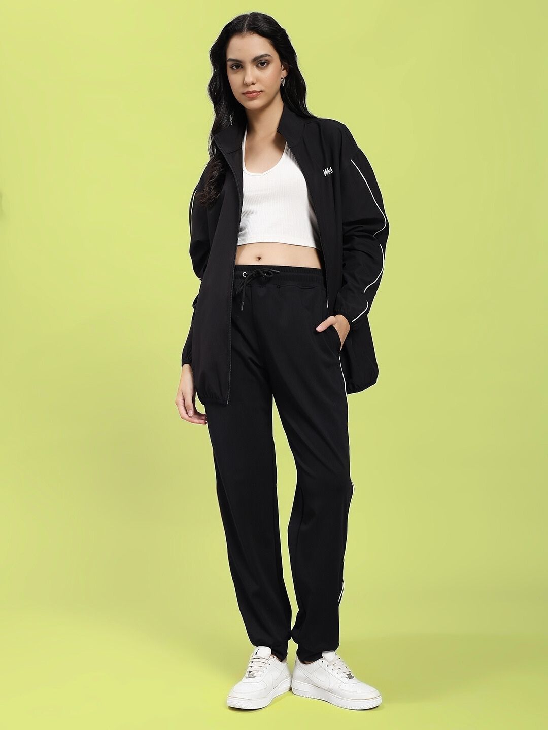 Model wearing WOMEN RELIGHT RELAXED FIT JACKET BLACK with reflective trims and relaxed fit, perfect for workouts and casual outings.