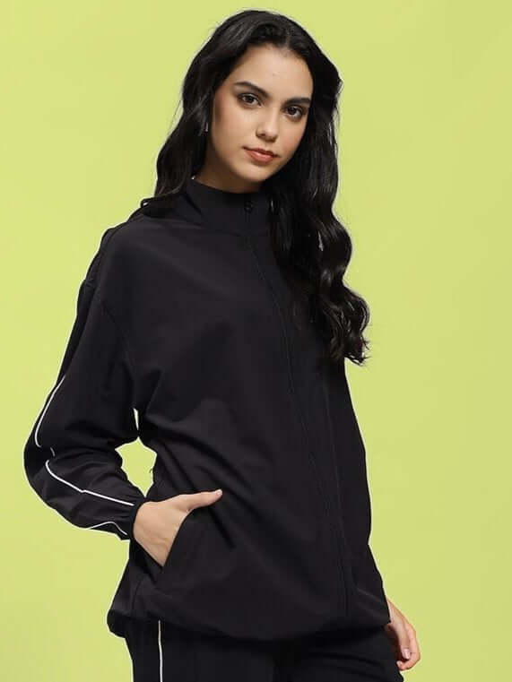 Woman wearing WOMEN RELIGHT RELAXED FIT JACKET BLACK with reflective trims for enhanced visibility.