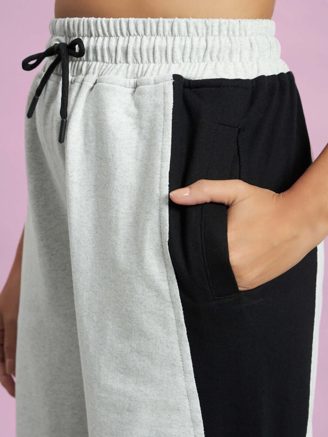 Close-up of Women's Revive Side Contrast Joggers in melange grey and black, showing pocket detail and adjustable drawstring.