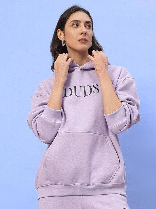 Woman wearing WOMEN RITZY FLEECE HOODIE LILAC by DUDS, lilac color, made-to-order cozy fleece with customization options.