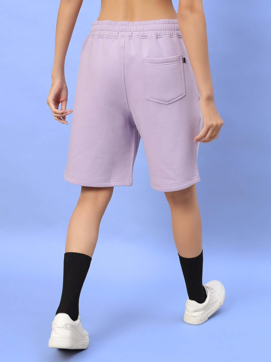Back view of WOMEN RITZY FLEECE SHORTS LILAC, showcasing pocket detail and elastic waistband.