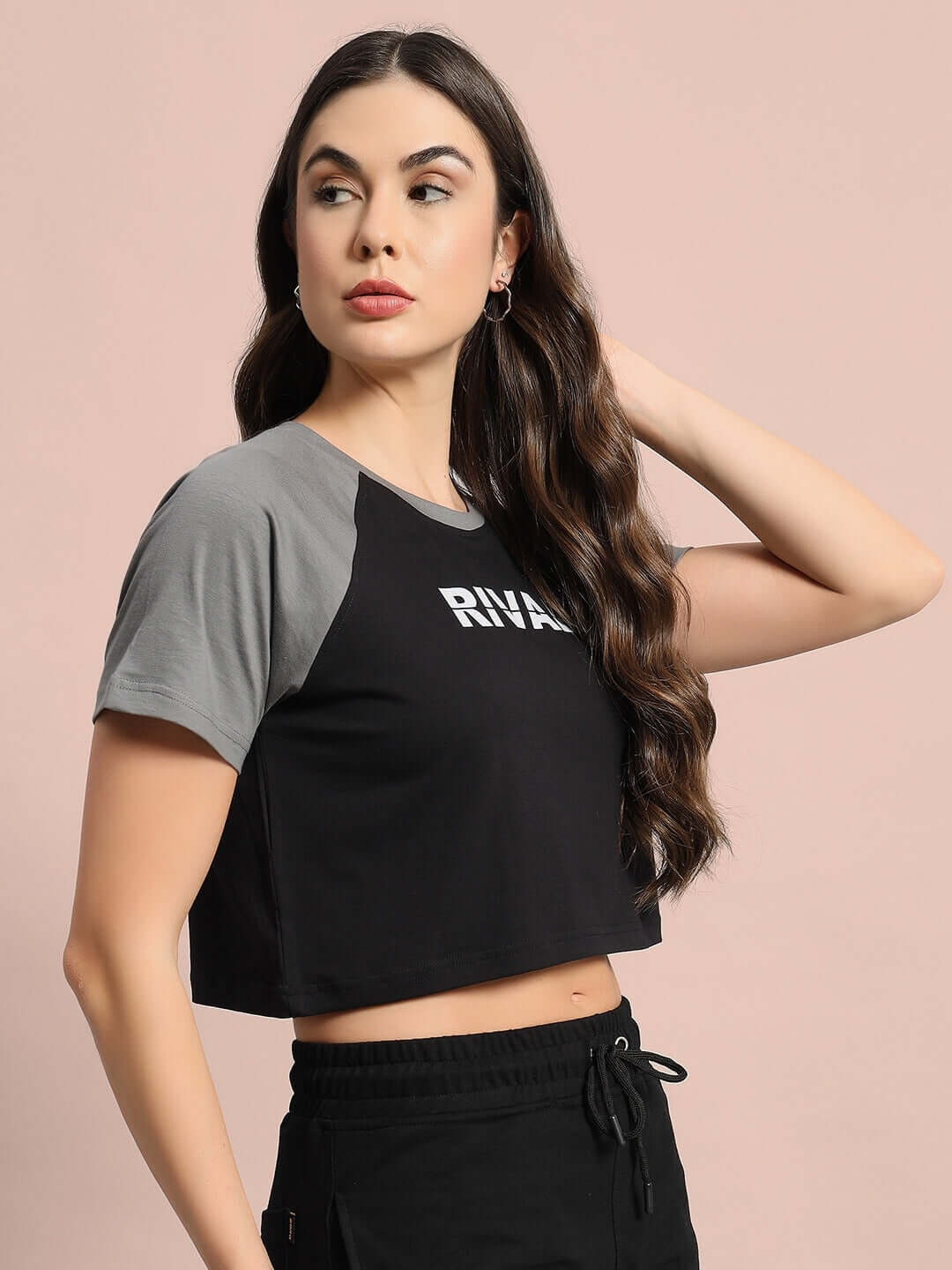 Women's black and grey raglan crop-top made from premium 100% cotton; modeled against a soft background. Stylish and comfortable fashion.