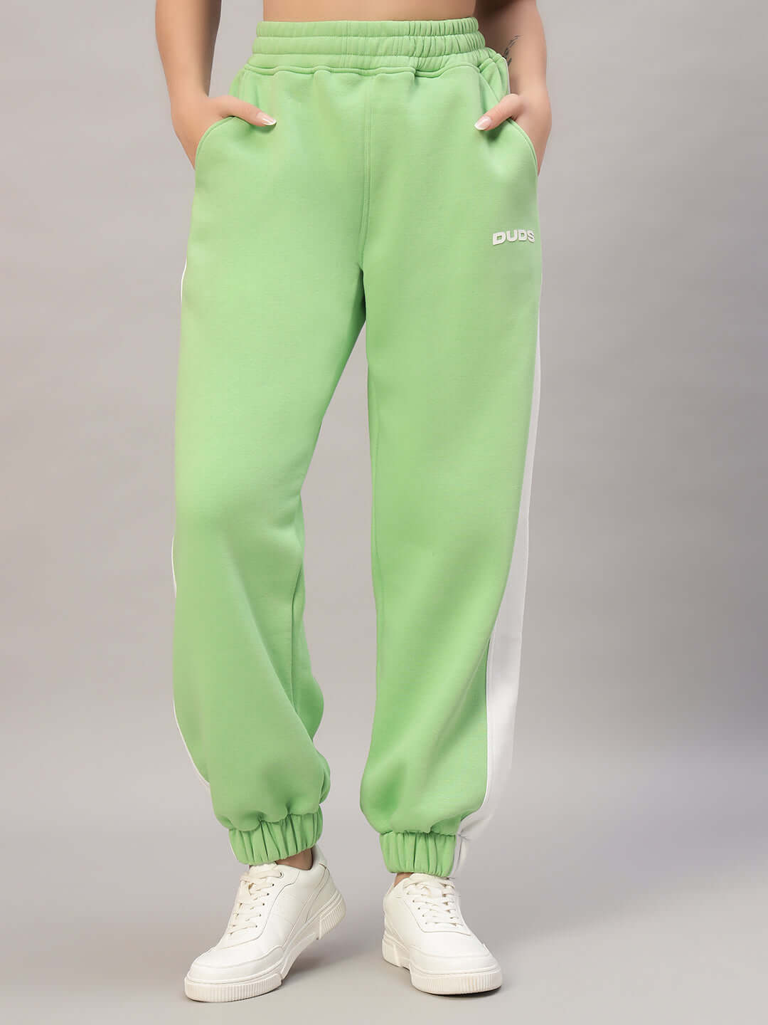 Model wearing Women's Rizzler Colorblock Co-ord pants in green, with white side stripe and elastic cuffs.