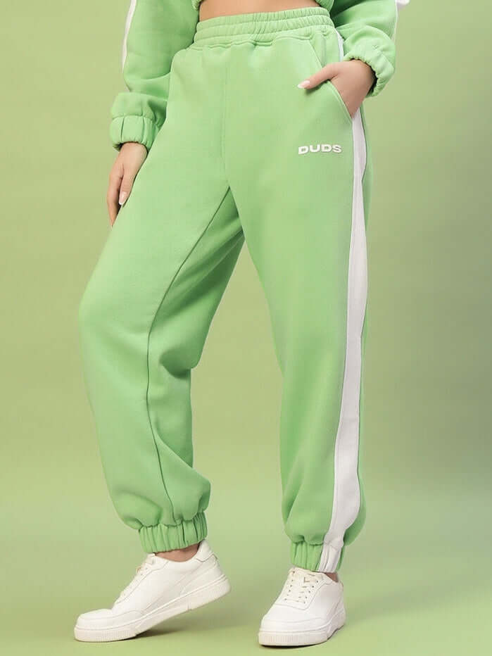 Model wearing WOMEN RIZZLER FLEECE COLORBLOCK JOGGER GREEN, showcasing vibrant green tones and cozy fleece fabric.