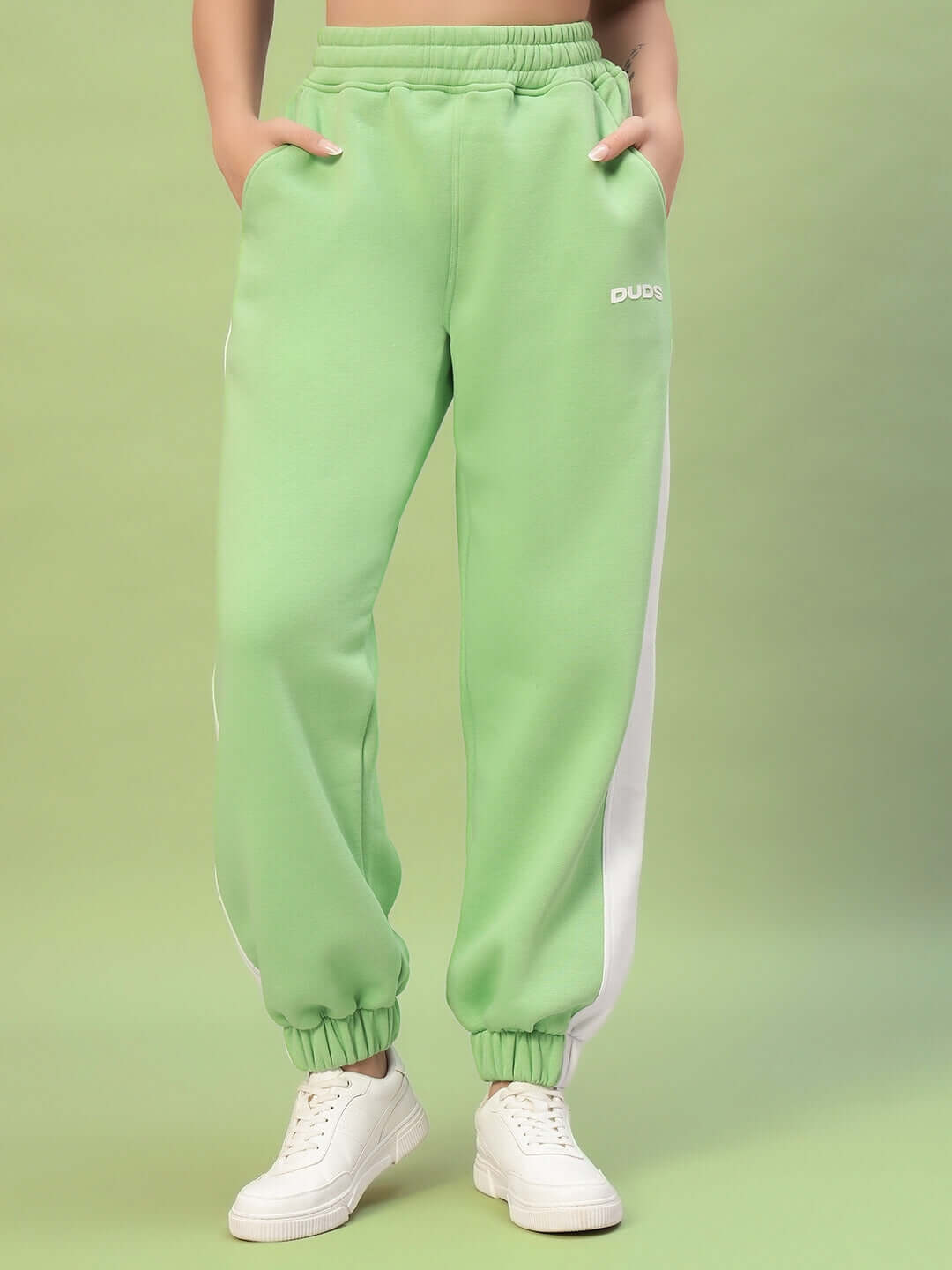 WOMEN RIZZLER FLEECE COLORBLOCK JOGGER GREEN on model, vibrant green fleece joggers, white side panels, casual streetwear fashion.