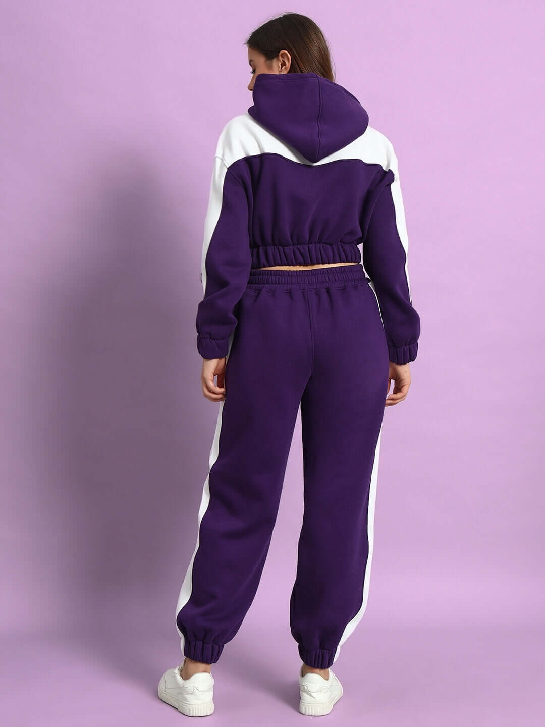 Alt Tag: Woman wearing WOMEN RIZZLER FLEECE COLORBLOCK JOGGER PURPLE, showcasing back view of stylish and cozy purple jogger set.