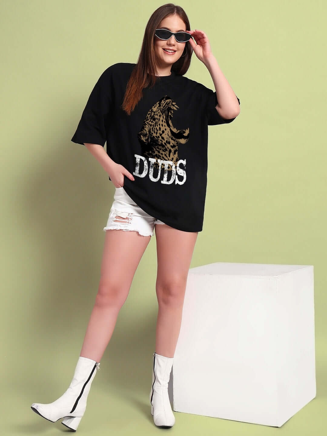 Model wearing WOMENS ROARING THUNDER PRINTED OVERSIZED T-SHIRT BLACK with white shorts and boots, showcasing bold streetwear style.