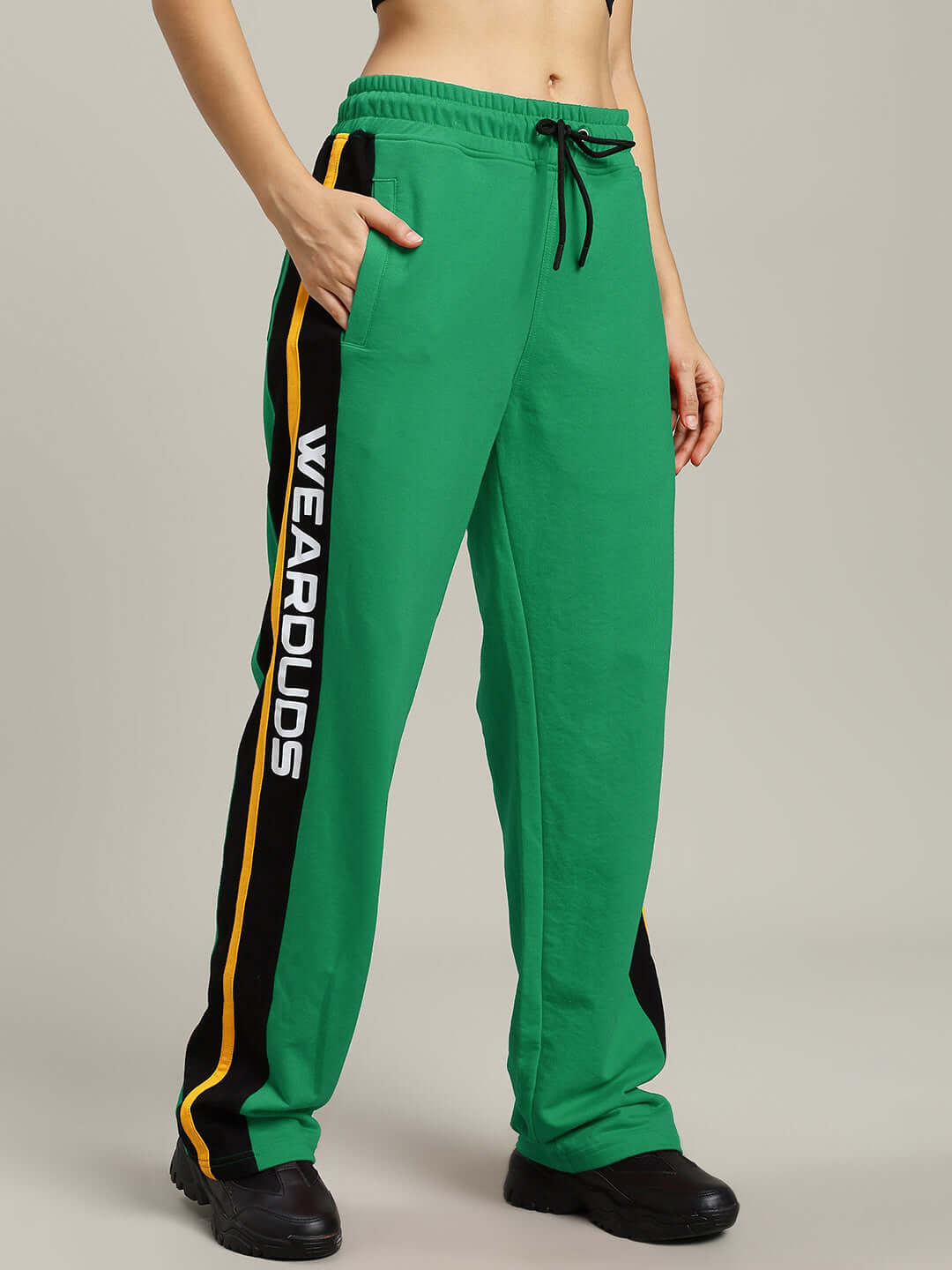 Woman wearing WOMENS ROGER RELAXED-FIT JOGGERS GREEN with elastic waistband and side stripes, showing casual style.