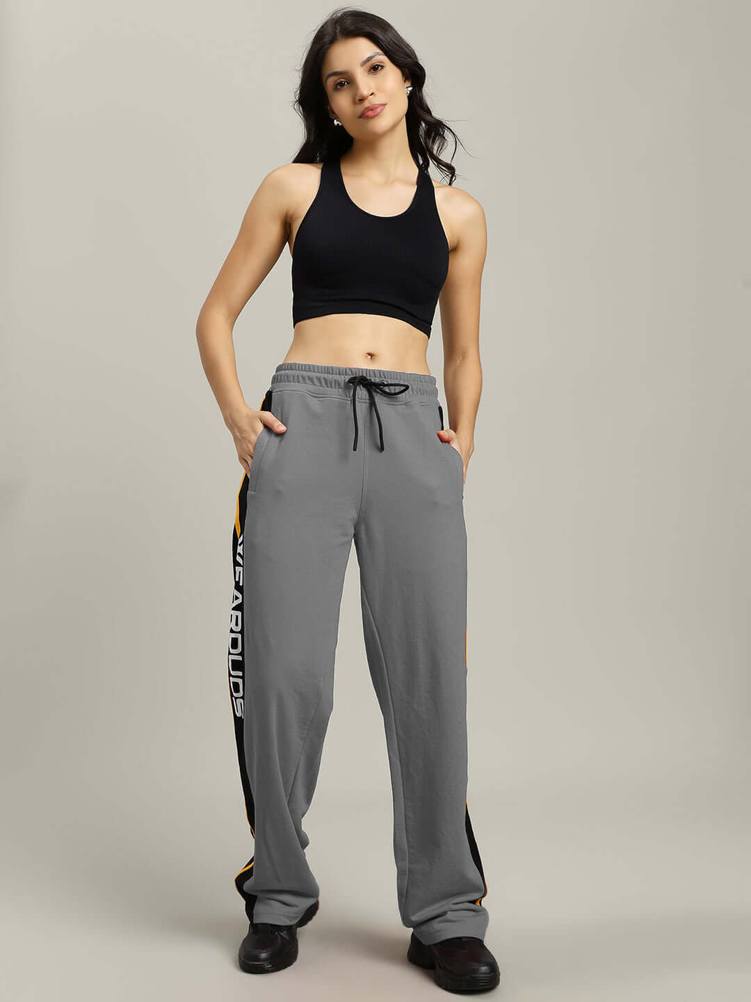 Woman wearing grey relaxed-fit joggers with black sports top, showcasing comfortable and stylish design for casual wear.