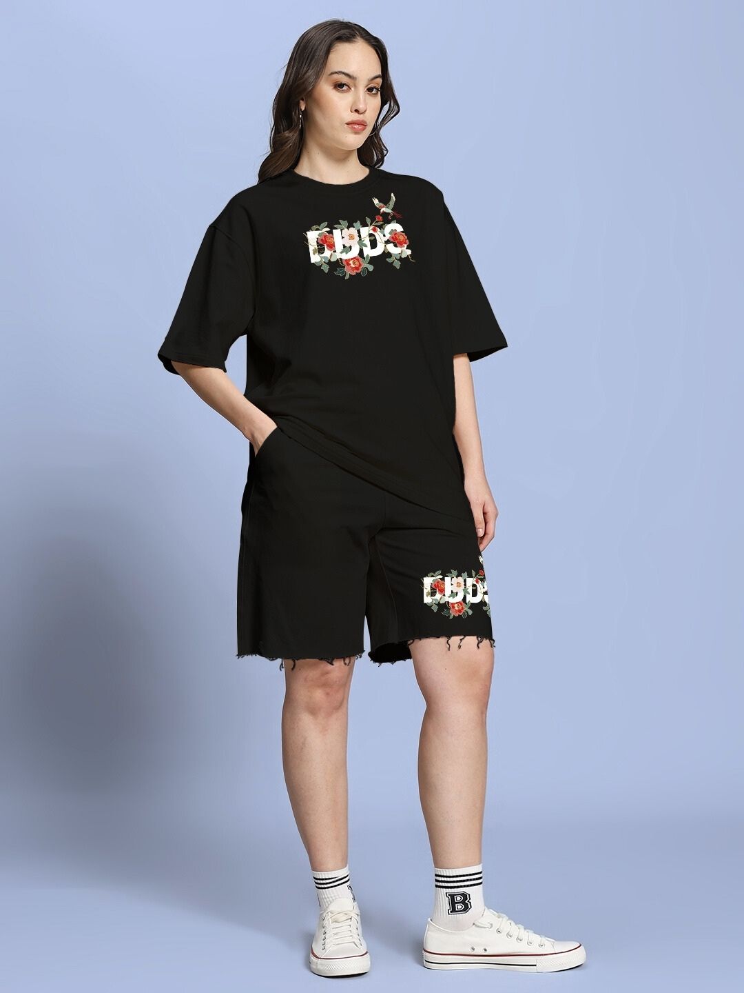 Woman wearing WOMEN ROSE CHARM OVER-SIZED T-SHIRT BLACK with floral design, casual chic style.
