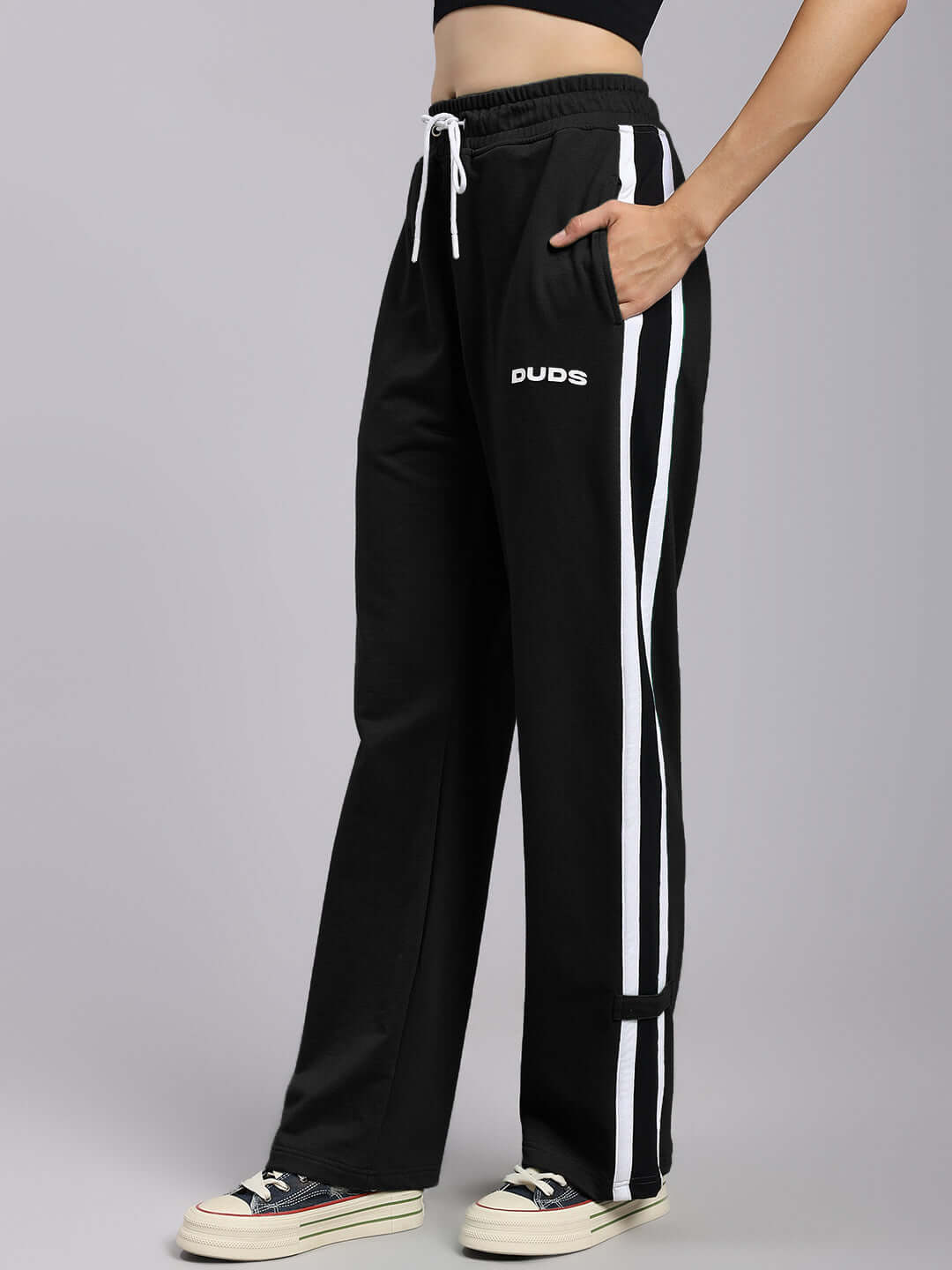 Model wearing Women's Rosston Flat-Out Relaxed Fit Joggers in black with white stripes, featuring DUDS logo and drawstring waist.