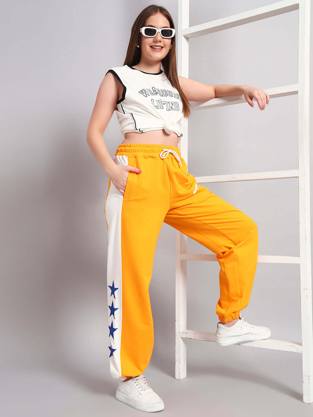 Woman wearing Women's Rox Primer Relaxed Fit Joggers in orange-white, styled with a sporty top and sneakers, DUDS tailored fashion.