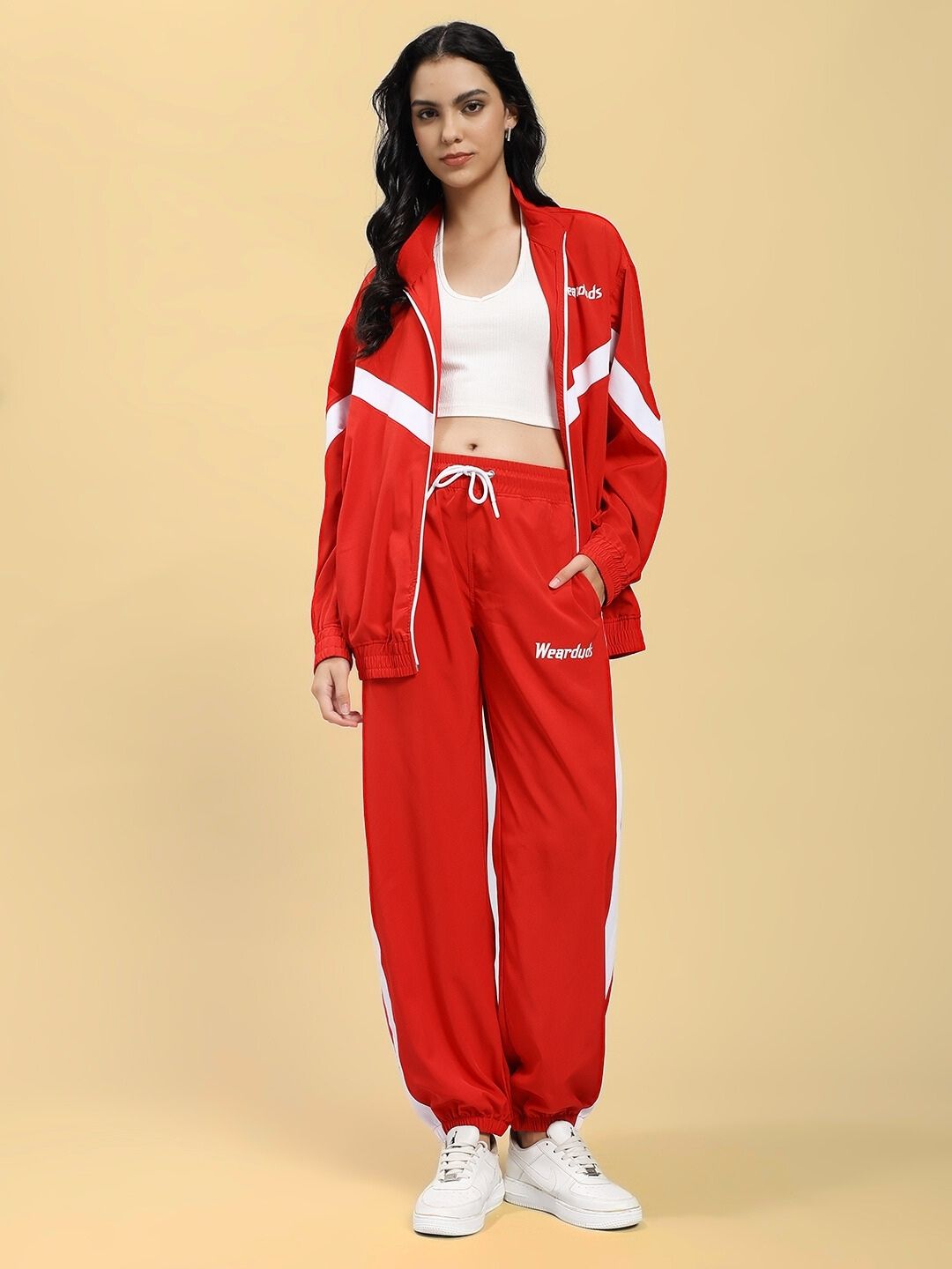 Woman wearing WOMEN'S ROYAL COMFORT RELAXED FIT JACKET RED, styled with comfortable matching pants, on beige background.