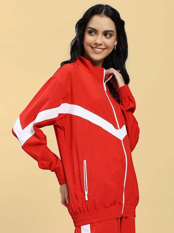 Woman wearing WOMEN ROYAL COMFORT RELAXED FIT JACKET RED with white stripes, exuding a stylish and comfortable look, on a beige background.