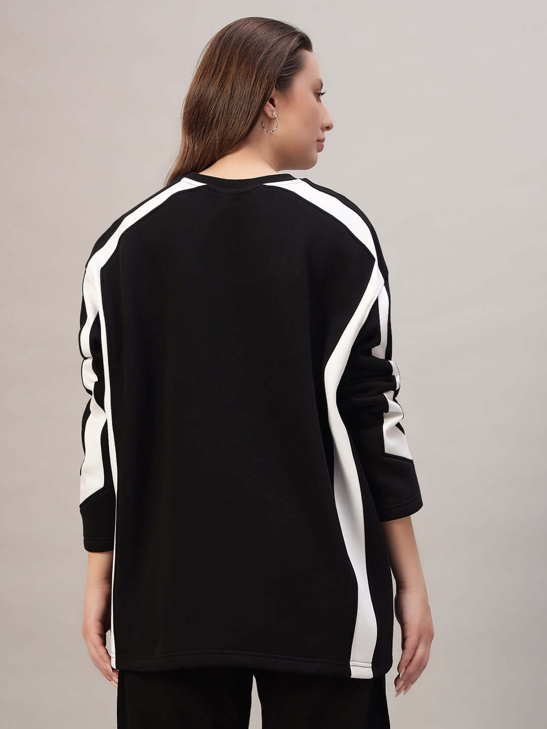 Rear view of model wearing WOMEN RUGBY OVERSIZED FLEECE SWEATSHIRT BLACK with sporty-chic design and relaxed fit.