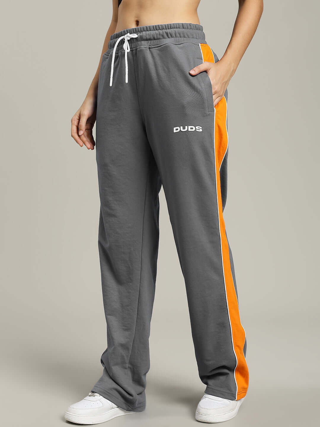 Woman wearing WOMENS SANFORD STRIPE JOGGERS GREY with orange side stripes, showcasing a stylish and comfortable fit.