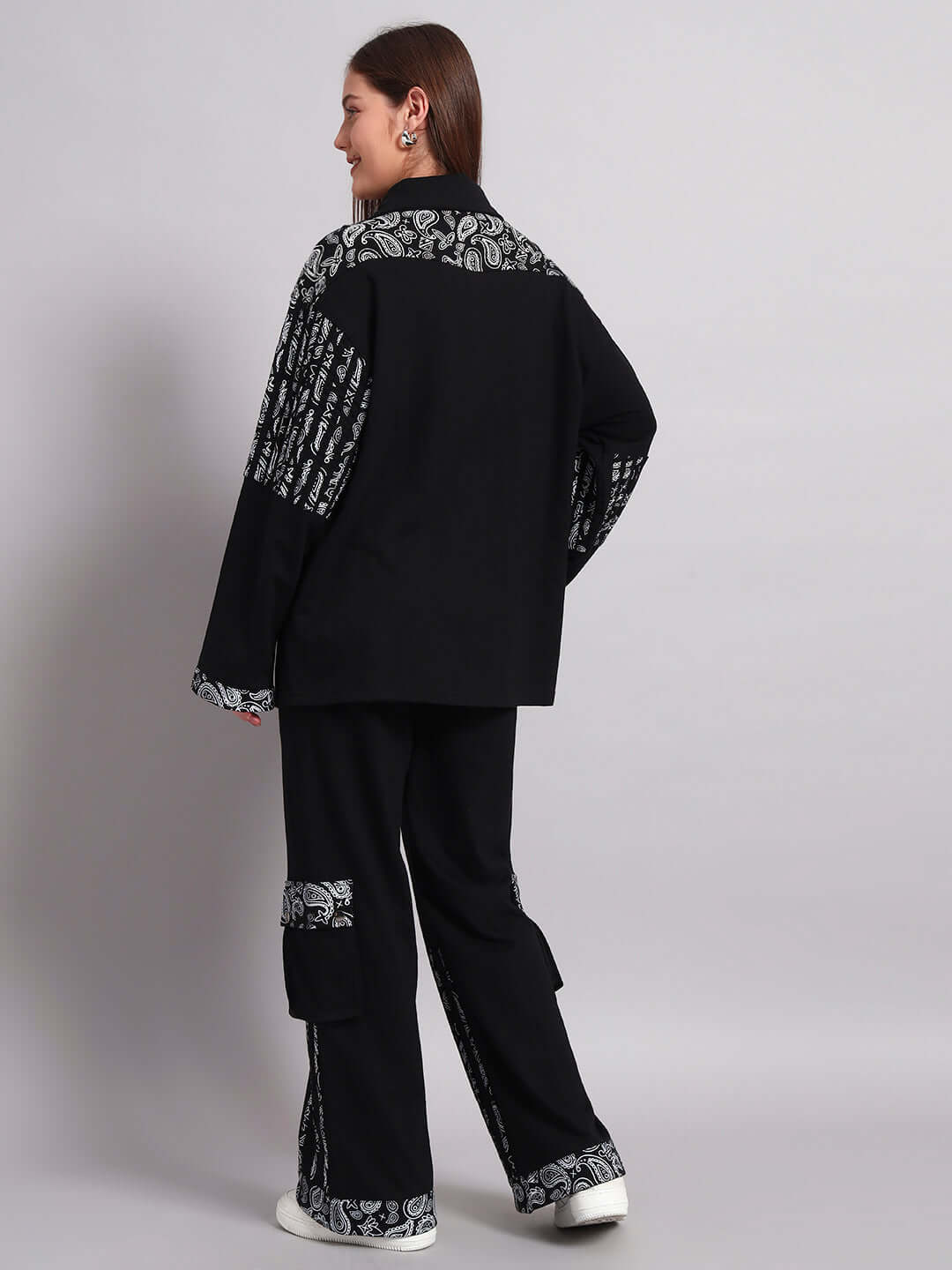 Woman wearing black Sanganeri joggers with white patterns, side view, showcasing comfortable and stylish design by DUDS.