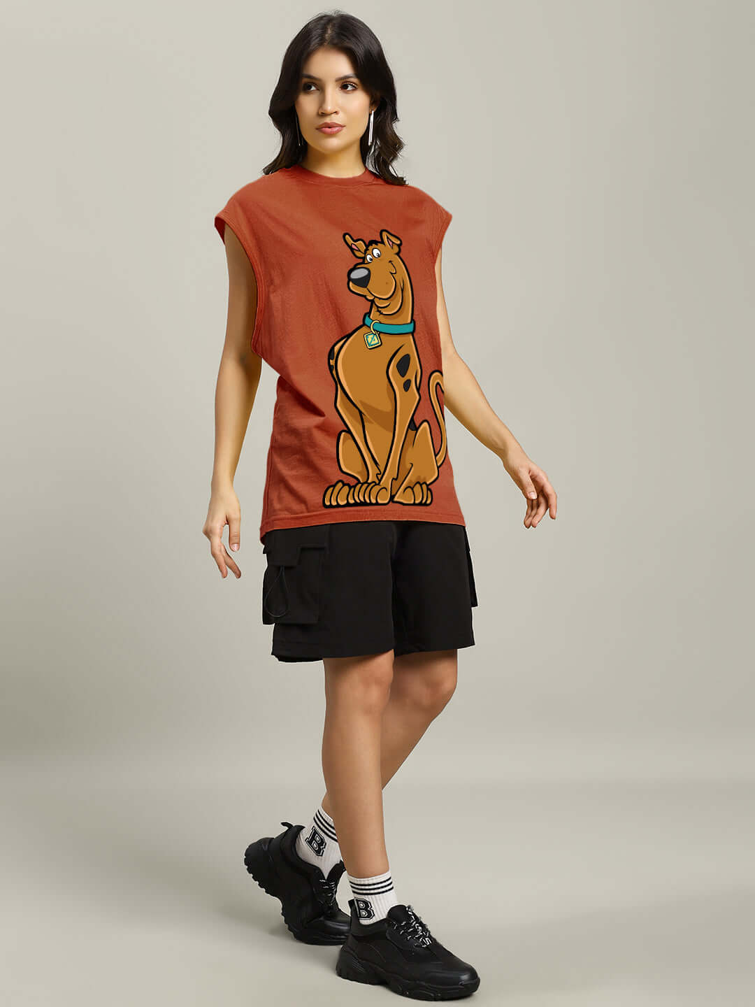 Woman wearing a brown Scooby Doo gym t-shirt with black shorts and black shoes.