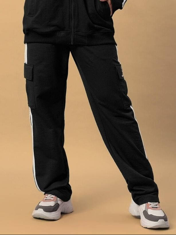Woman wearing black joggers with white stripes and sneakers, showcasing the stylish Women's Scotia Stripe Joggers by DUDS.