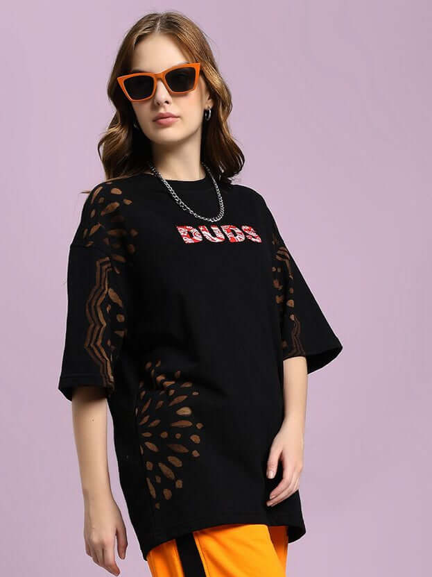 Model wearing WOMEN'S SHADOW SWIRL TIE-DYE T-SHIRT BLACK with subtle tie-dye pattern and orange sunglasses, styled casually.