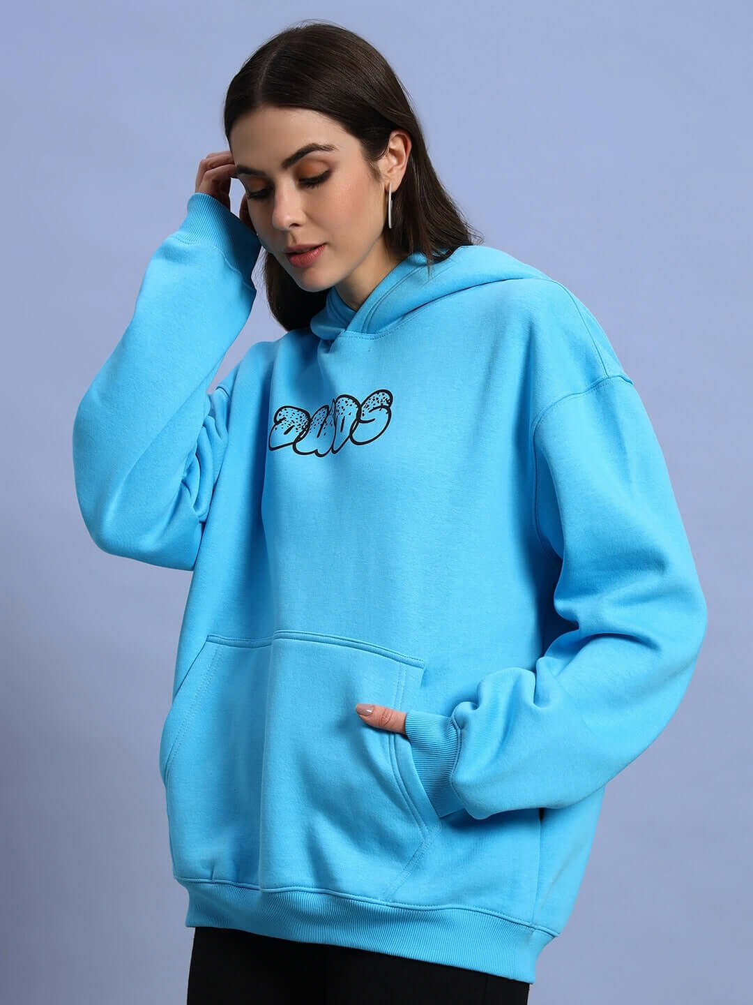 Woman wearing WOMEN SHARKWAVE FLEECE OVERSIZED HOODIE LIGHT BLUE, standing against a light background, showcasing cozy and chic style.