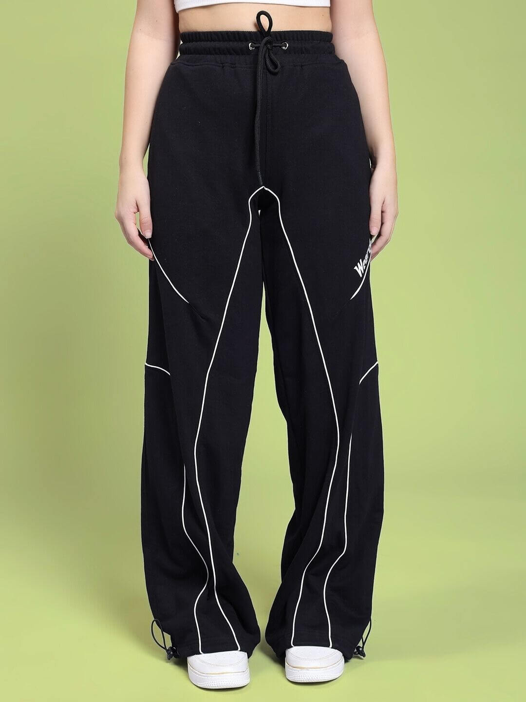 Woman wearing WOMEN SIGNATURE PIPING JOGGERS BLACK with contrast piping detail.