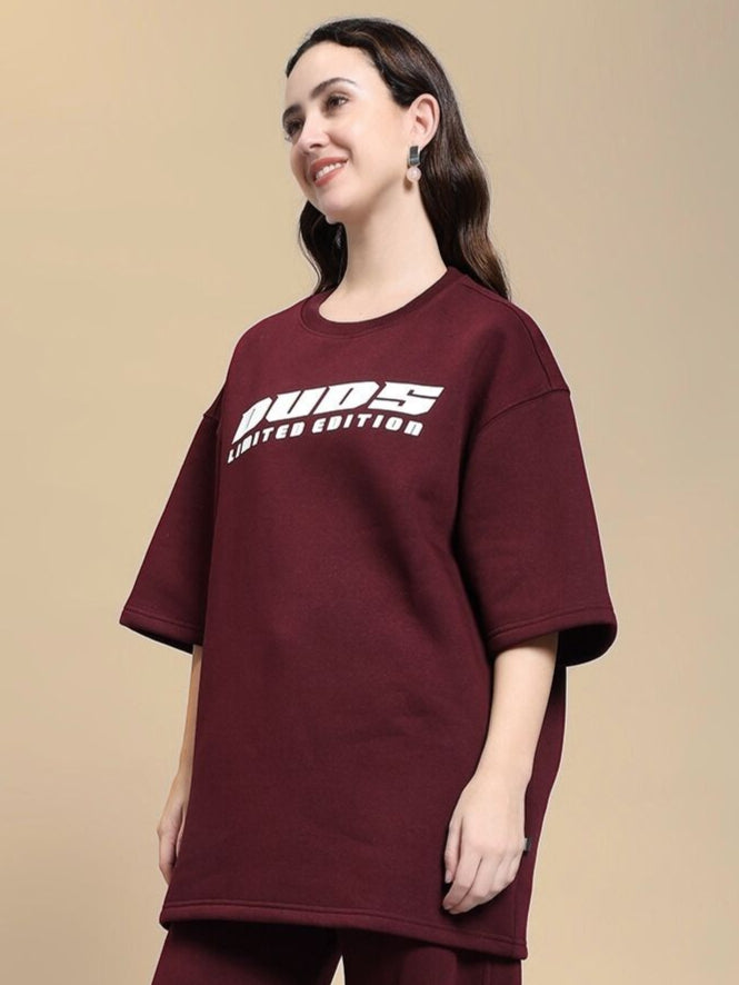 Model wearing WOMEN'S SKODA FLEECE OVERSIZED T-SHIRT MAROON, loose fit, comfy style, embroidered text, suitable for casual wear.