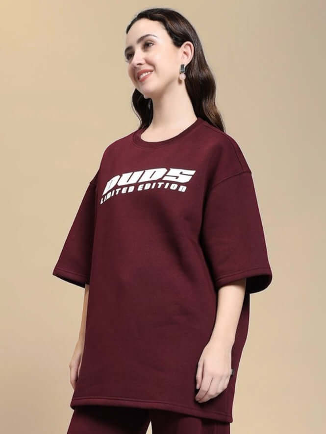 Woman wearing WOMEN SKODA FLEECE OVERSIZED T-SHIRT MAROON with graphic print, showcasing a cozy-chic style in deep maroon color.