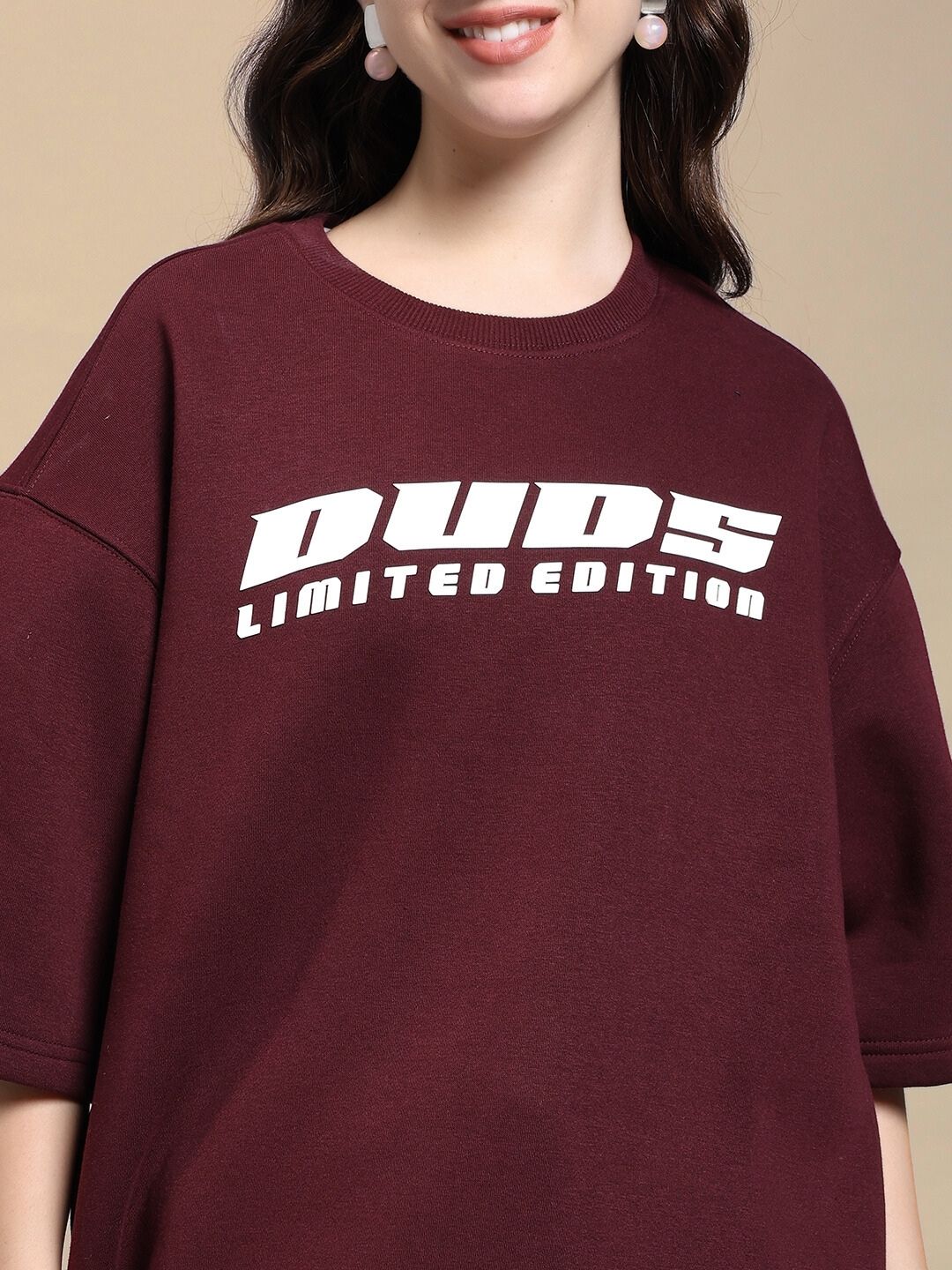 Model wearing WOMEN'S SKODA FLEECE OVERSIZED T-SHIRT MAROON featuring "DUDS Limited Edition" print.