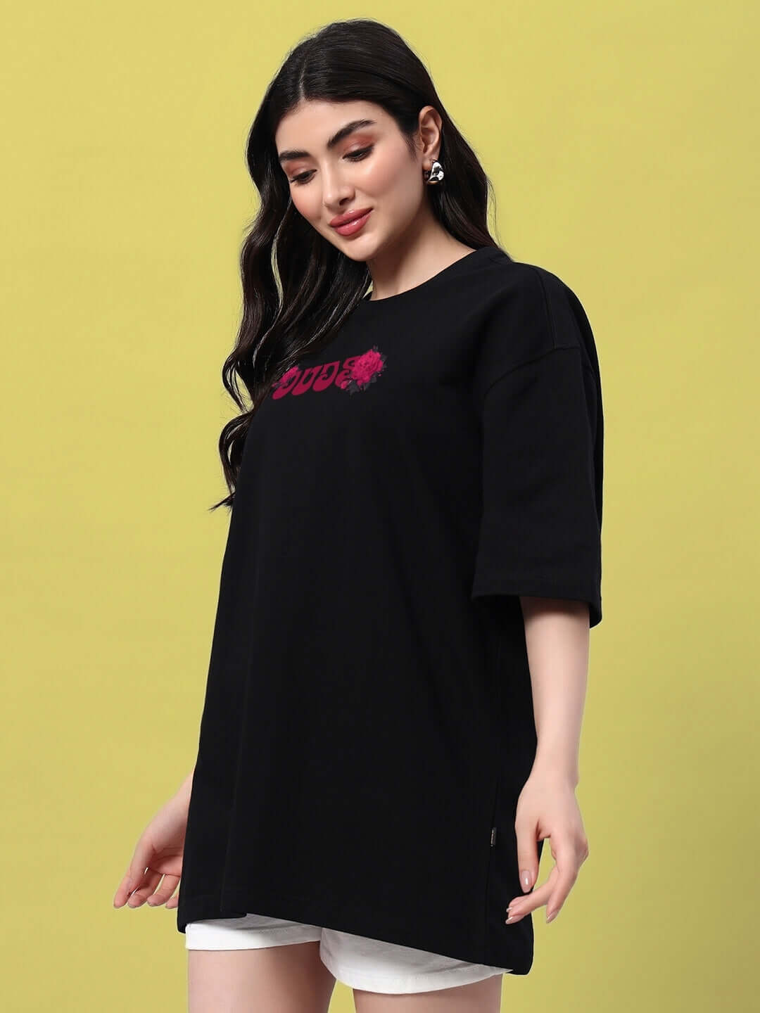 Woman wearing black oversized t-shirt with skull roses design, perfect for a trendy summer look.