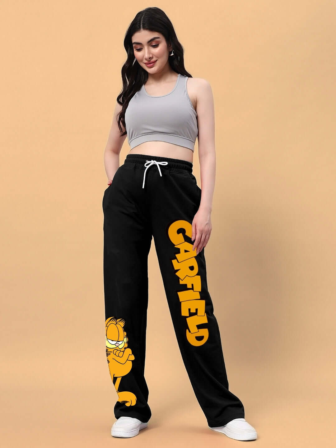 Woman wearing black Garfield relaxed fit joggers with yellow print, emphasizing comfort and style.
