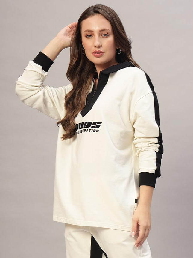 Woman wearing oversized off-white and black sweatshirt made of premium cotton fabric, comfortable and stylish design.