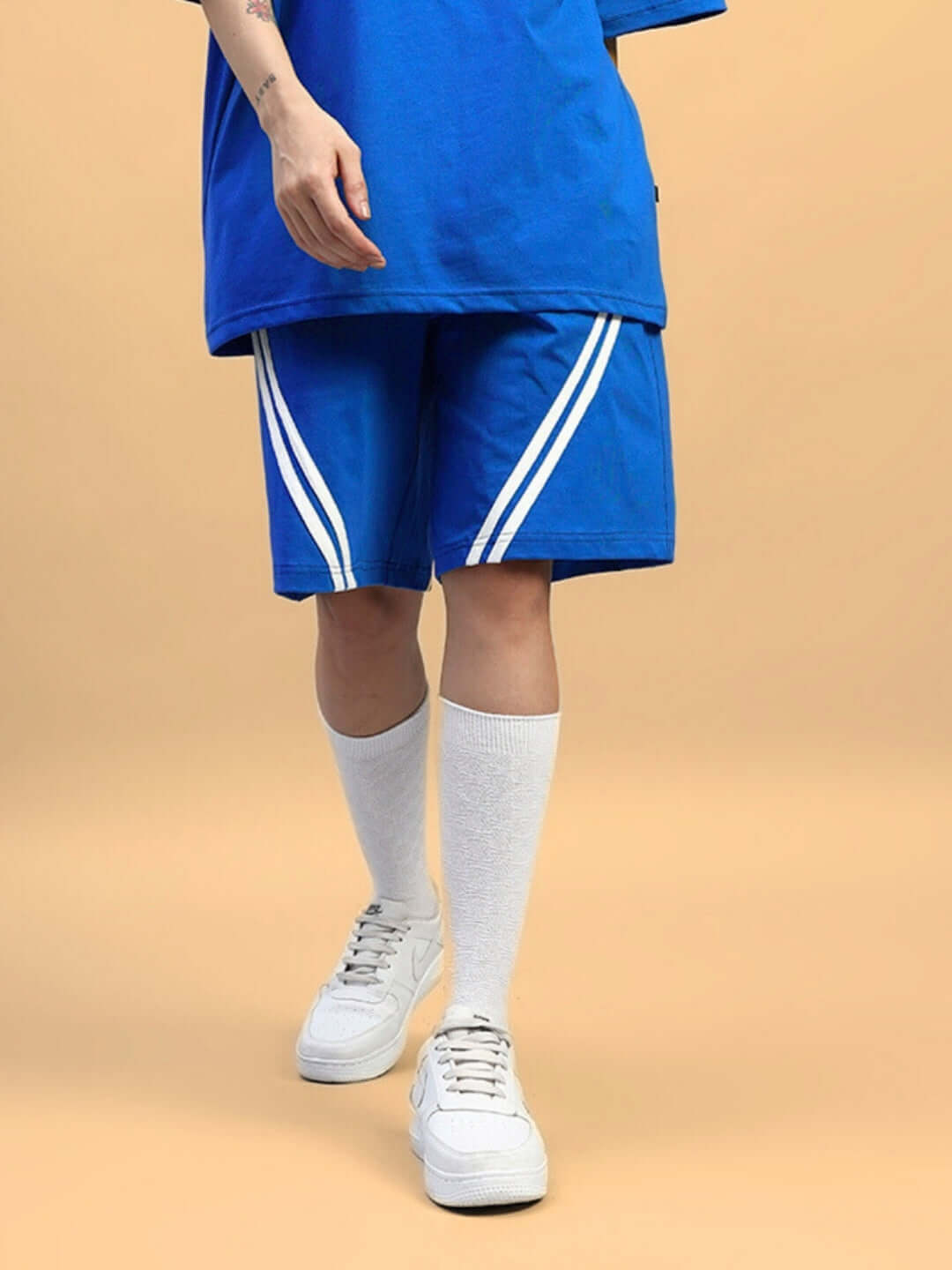 Blue women's star jumper regular fit shorts with white stripes, styled with white knee-high socks and sneakers.