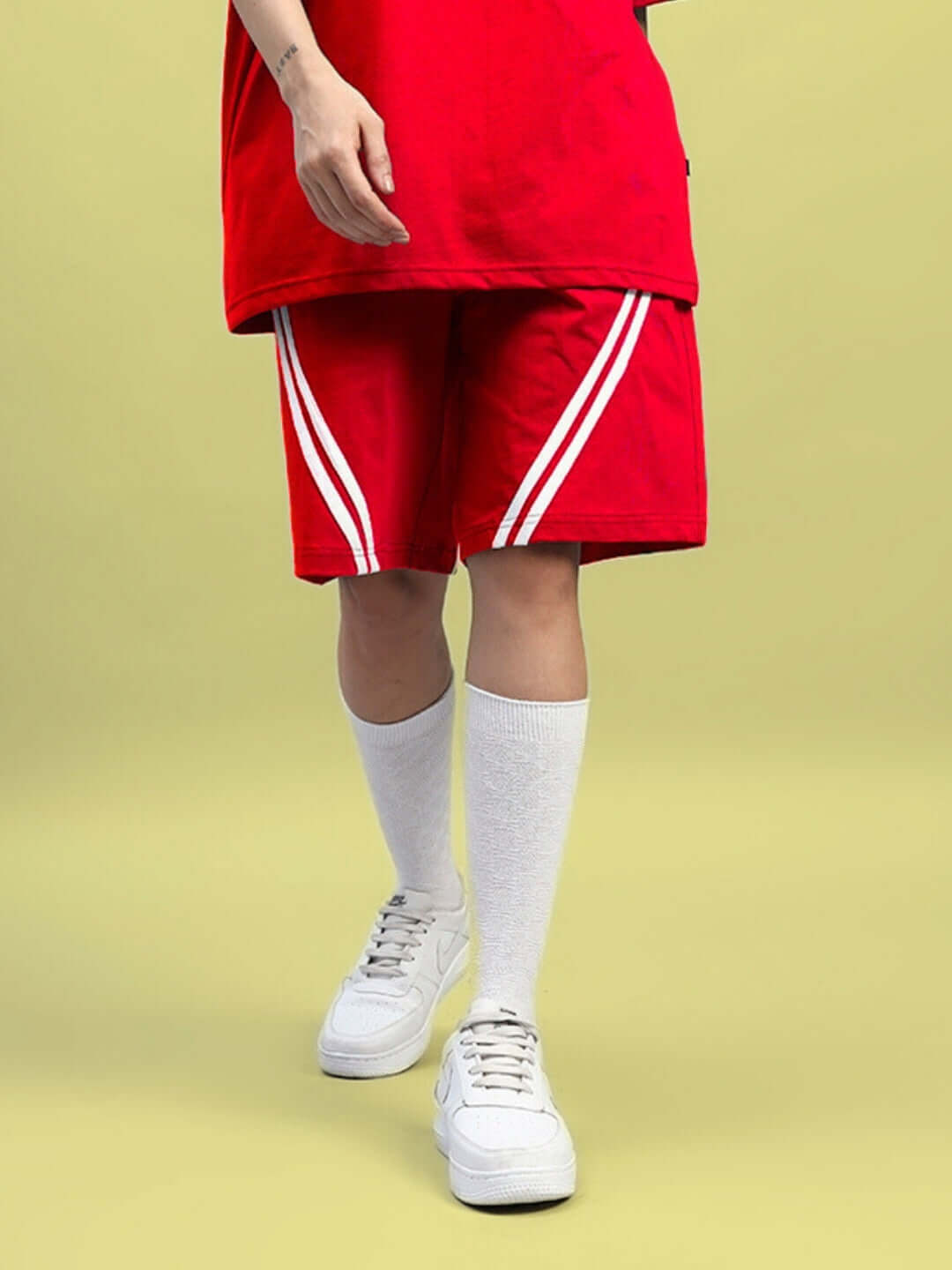 Women's star jumper red shorts, regular fit, showcased with white sneakers and socks against a neutral background.