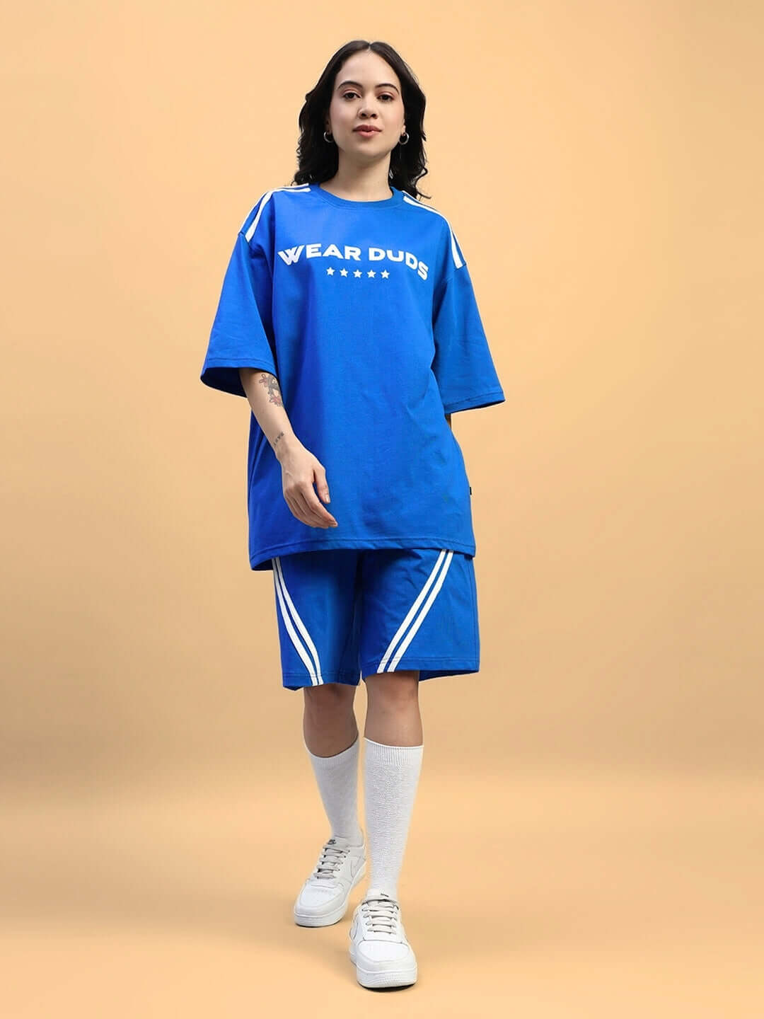 Model wearing WOMENS STAR JUMPER SUMMER CO-ORD SET BLUE, featuring oversized t-shirt and shorts, perfect for summer streetwear style.