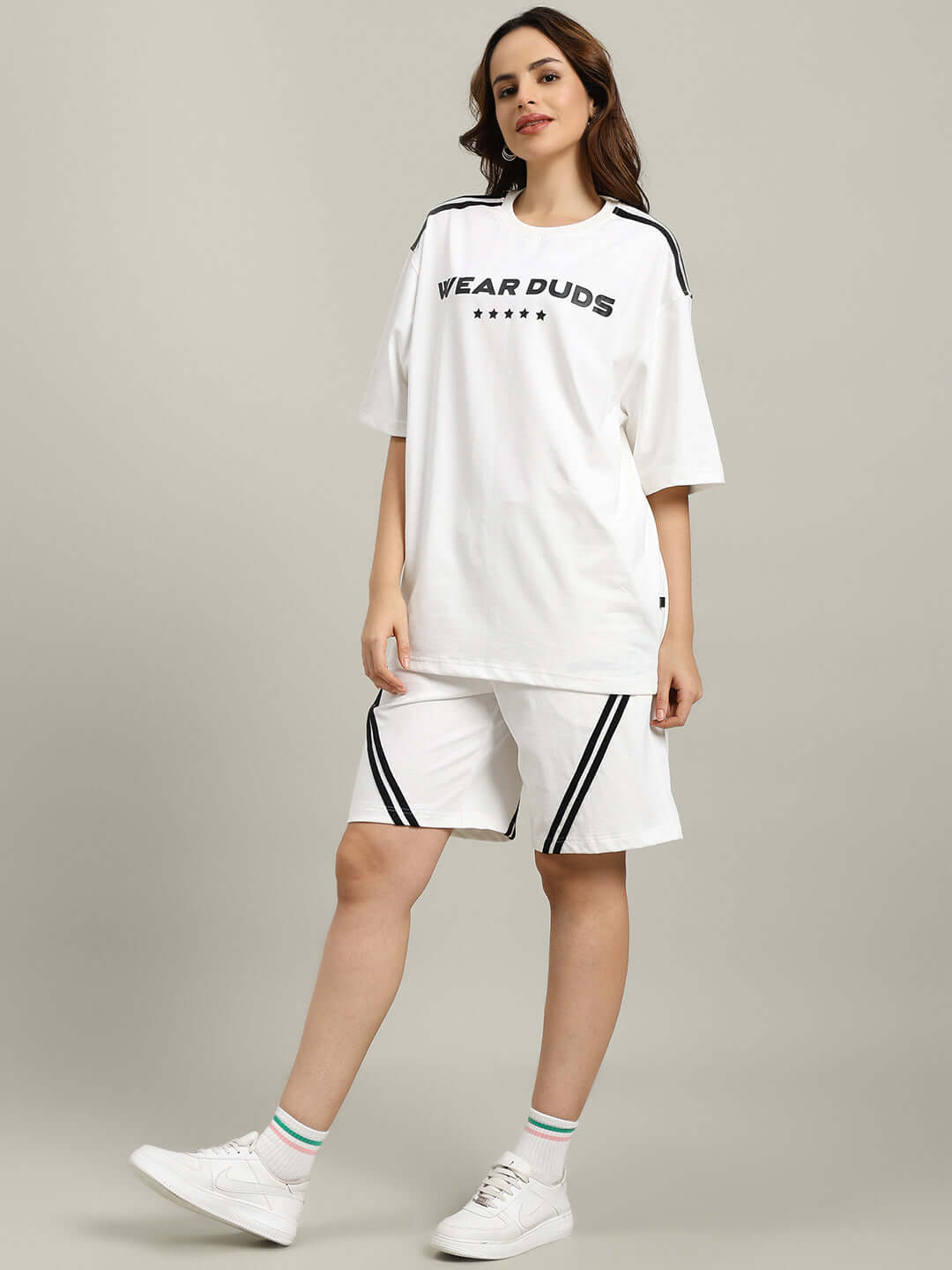 Woman wearing WOMEN'S STAR JUMPER SUMMER CO-ORD SET OFF WHITE, featuring casual style with t-shirt and shorts.