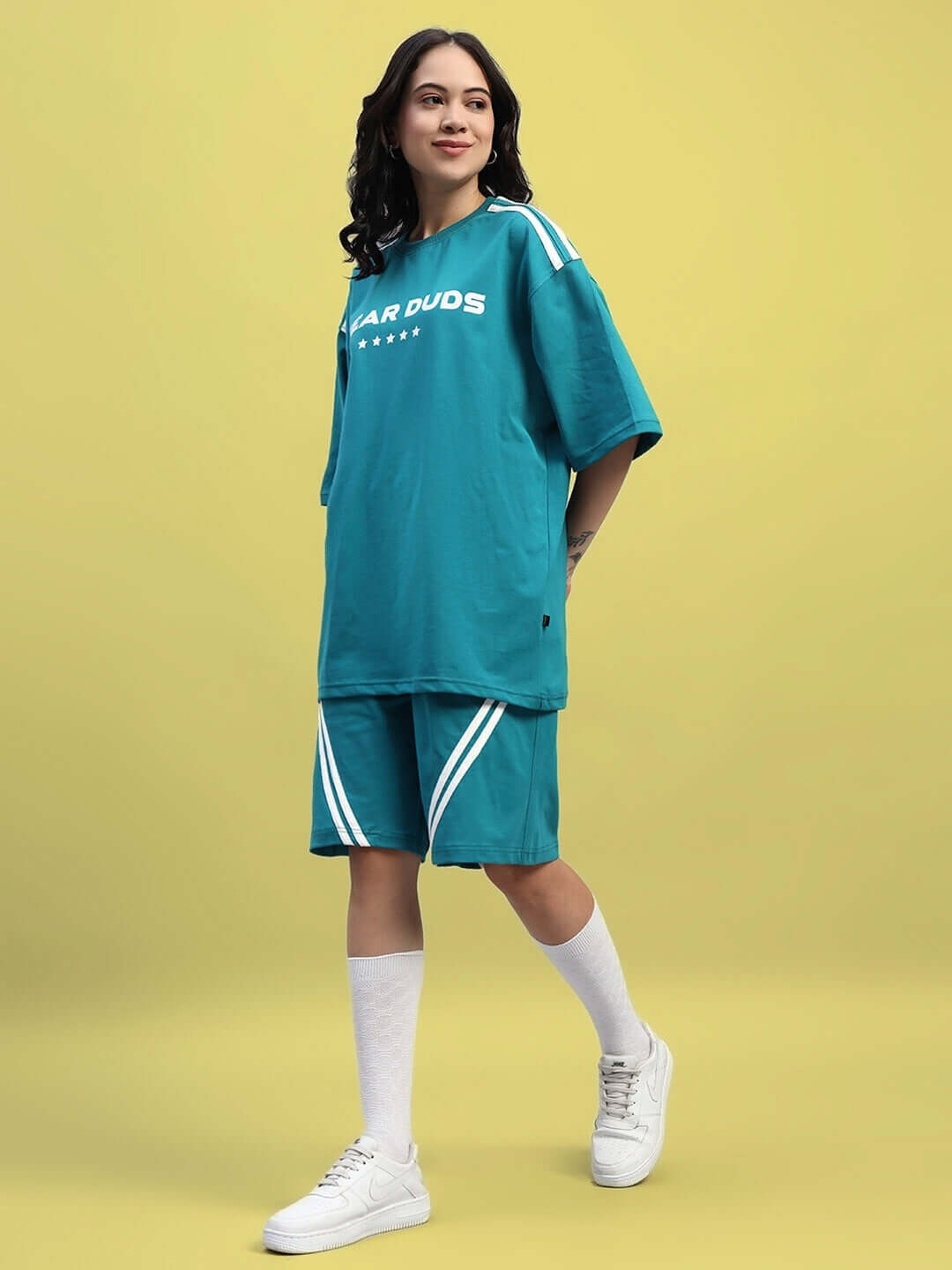 Woman wearing WOMEN'S STAR JUMPER OVER-SIZED T-SHIRT TEAL with star details