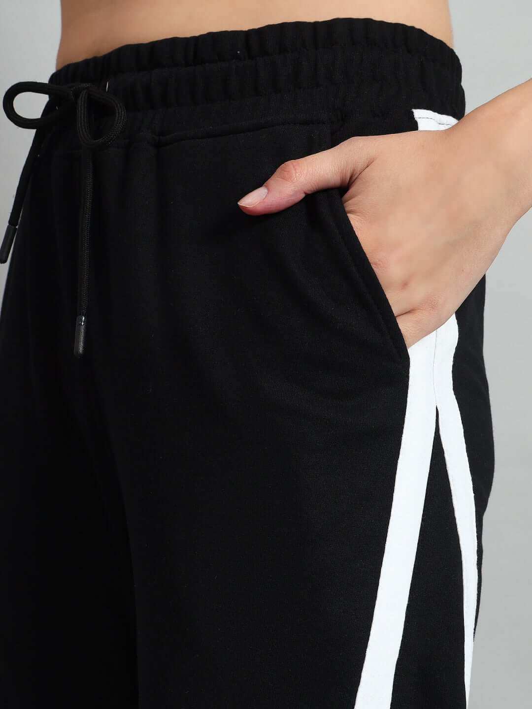 Close-up of Women's Stellar Relaxed Joggers in black with white accents, featuring an adjustable drawstring waistband and side pocket.