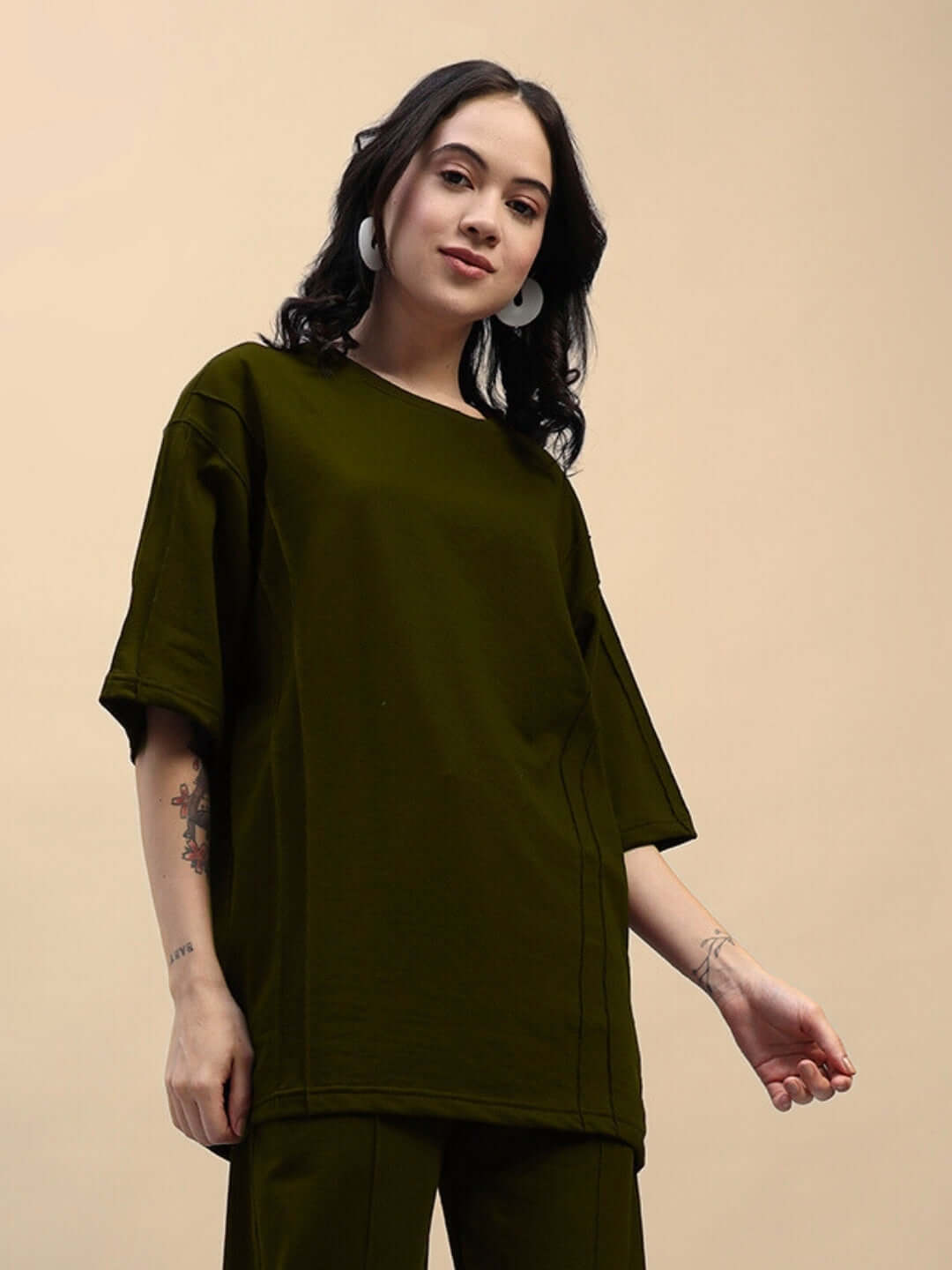 Woman wearing olive green oversized t-shirt made from premium cotton French terry lycra, showcasing casual style and comfort.