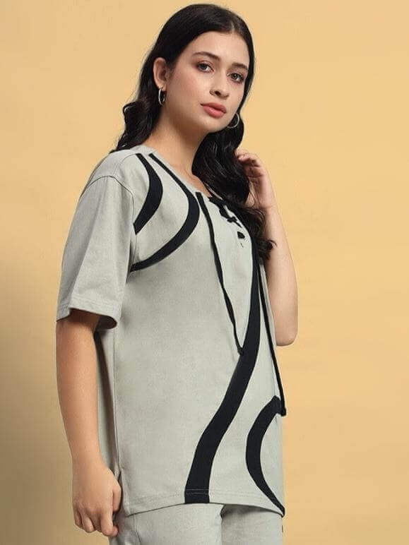 Woman wearing an oversized grey designer surfing t-shirt with black abstract design, made from premium cotton blend.