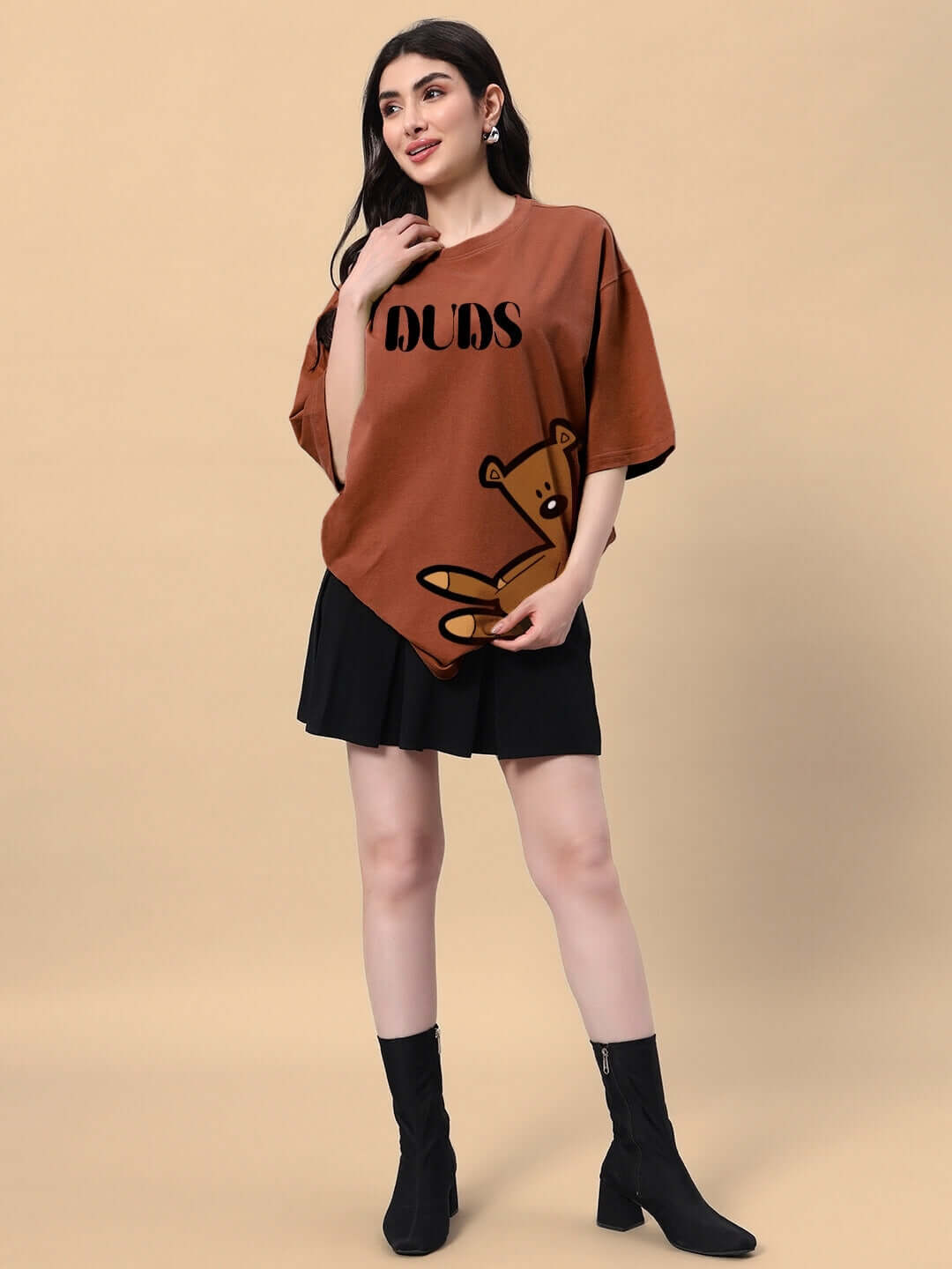 Woman wearing brown Women's Teddy Bean T-shirt in heavy gauge fabric with bear design, paired with black skirt and boots.
