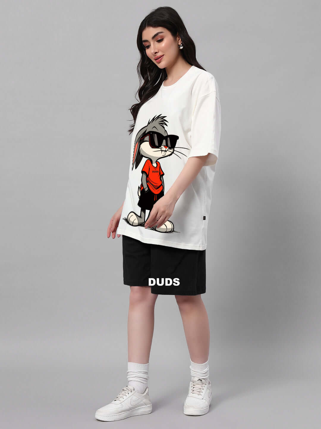 Model wearing Women's Think Big Bunny Toons Co-ord Set in off white and black, featuring a Bugs Bunny graphic, styled with white sneakers.