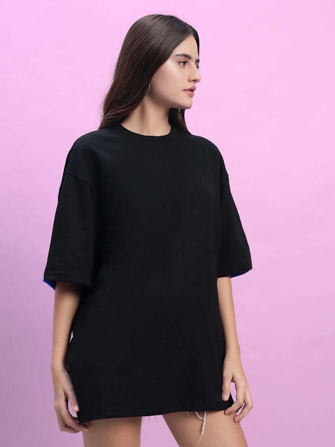 Black-blue oversized women's t-shirt, premium cotton fabric, modeled against a pink background, showcasing loose and comfortable fit.